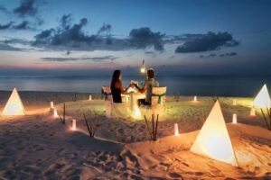 couples on the beach near caribbean bungalow over water